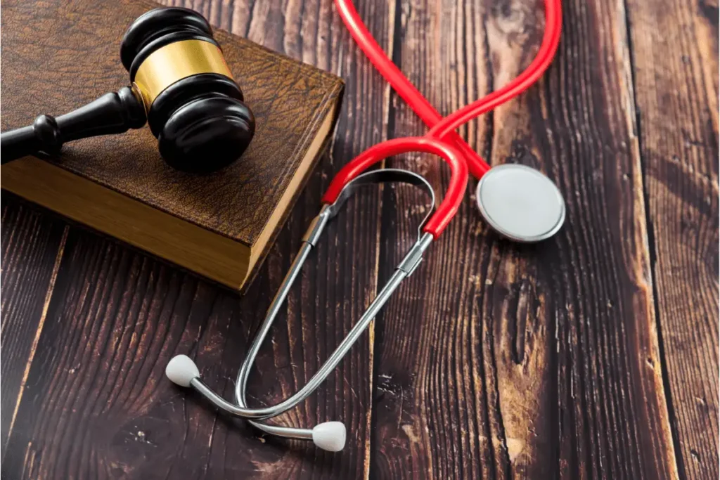 Gavel, law book, and stethoscope on a wooden table
