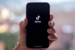 hand holding phone with Tik Tok logo on screen