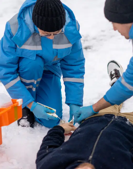 People attending to an accident victim during the winter