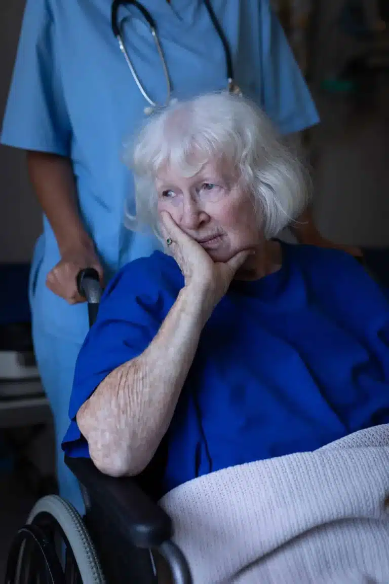 An aged woman on a wheelchair with her nurse