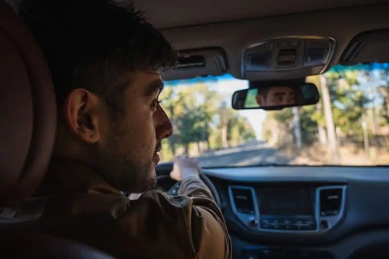 A man driving a car pictured from sideview