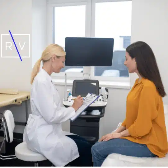 Female doctor consulting with a patient in a medical office, discussing treatment or injury evaluation during a clinical visit.