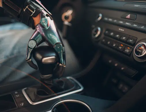 Young disabled man driver with artificial prosthetic hand driving vehicle car.