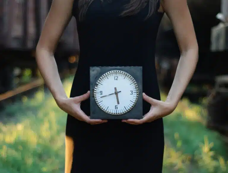 Woman holding clock in black dress