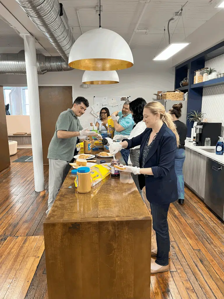 Richmond Vona team members making sandwiches for a donation drive in their office kitchen.