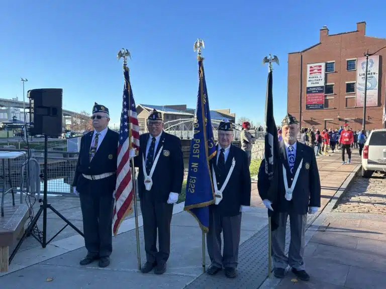 Group of individuals standing outdoors holding flags during the community event