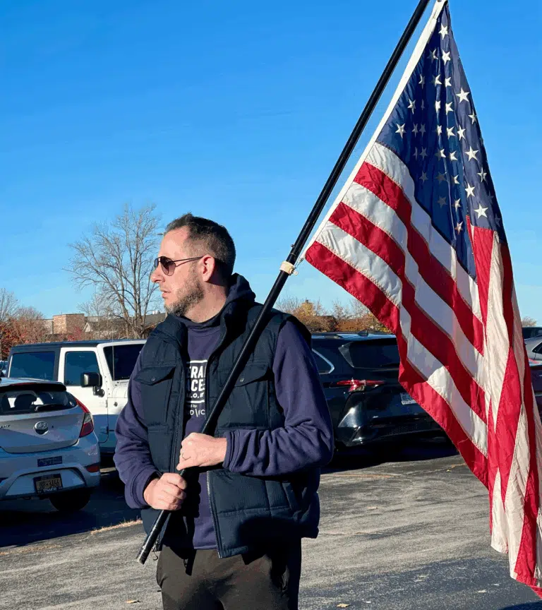 Man holding an American flag during a Richmond Vona community outreach
