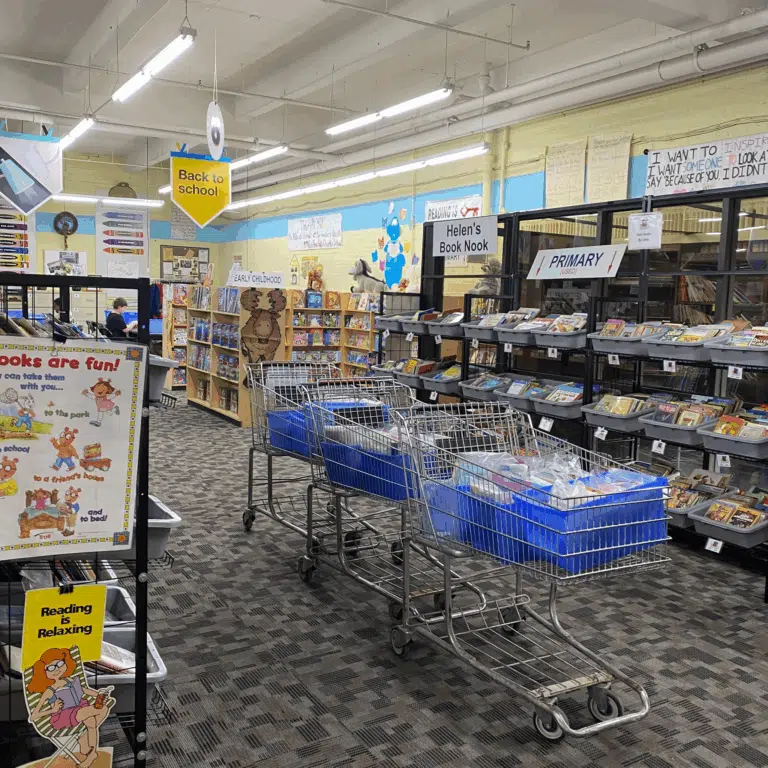 Resource center aisle stocked with school supplies and shopping carts loaded for a donation drive.