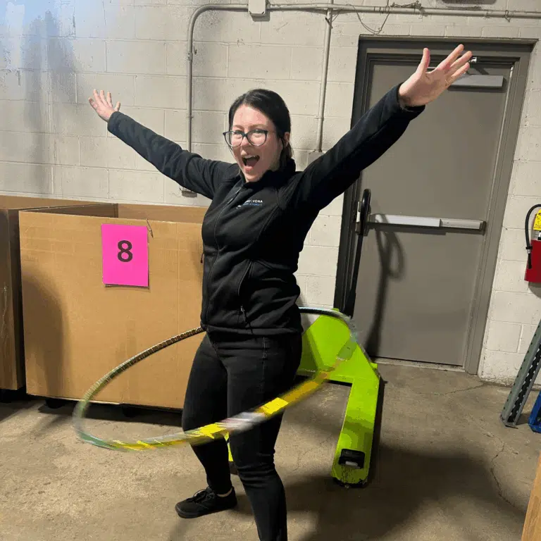 Woman hula hooping indoors during a community outreach activity