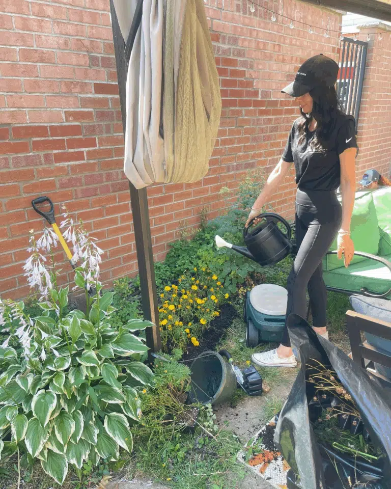 A woman caring for plants during a community outreach activity
