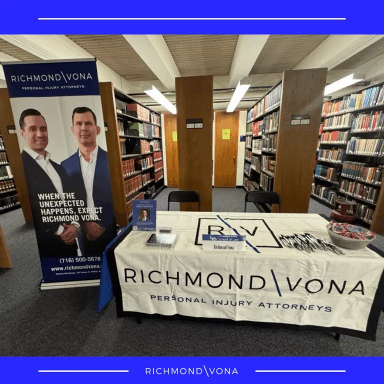 Richmond Vona Personal Injury Attorneys information booth set up in a library with a banner.