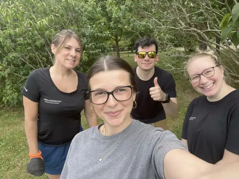Group of people smiling together outdoors during a community outreach activity
