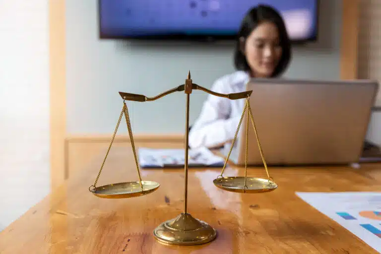 Gold brass balance scale over with lawyer background.