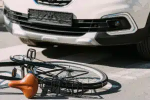 close up view of broken bicycle and car on road