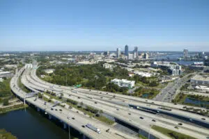 American freeway intersection with fast driving cars and trucks. View from above of USA transportation infrastructure.