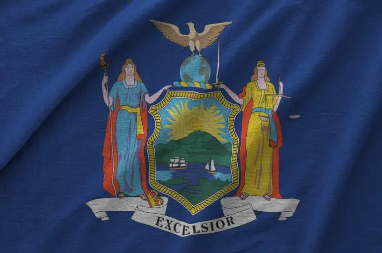 New York US state flag depicted on folded wavy fabric of old cloth close up