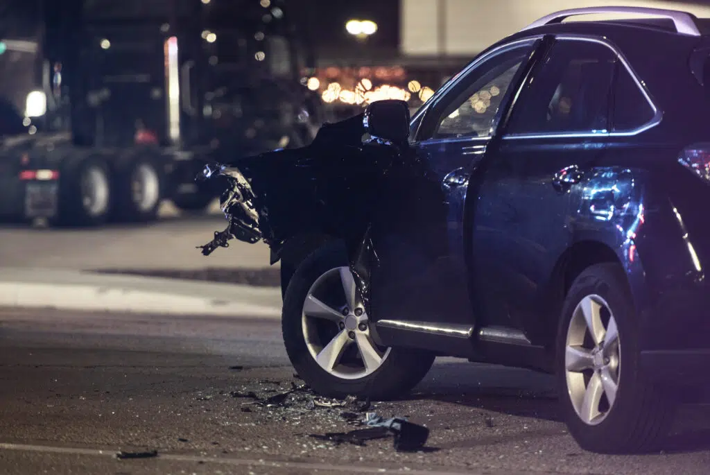 Traffic Accident Automotive Collision at Night. Heavy Damaged Modern Car on a Street. Transportation Safety Theme. Car Crash.