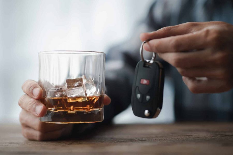 Man holding a glass of brandy, he is drinking brandy in a bar, drinking alcohol impairs driving ability and can damage health. The concept of drinking alcohol.